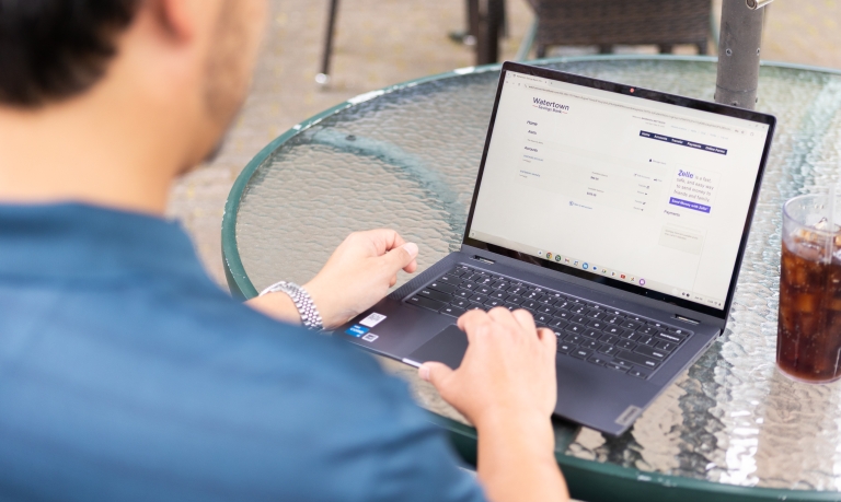 Man checking his business bank accounts on WSB online while sitting at a cafe.