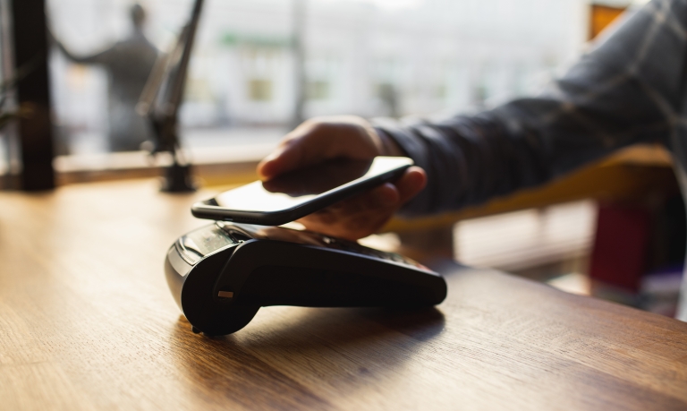 Customer making a payment using his mobile wallet on his phone.