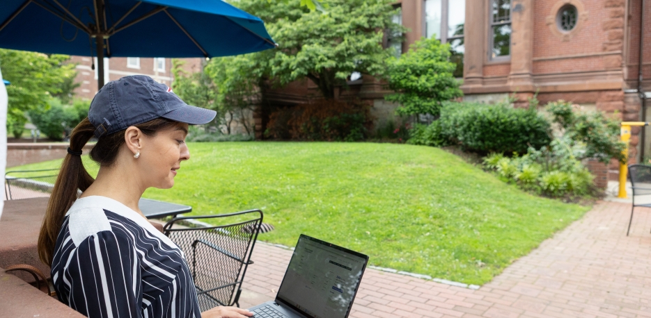 Woman checking her WSB bank account on her computer outside the library.