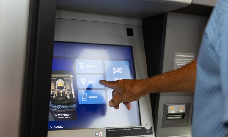 A customer choosing to make a deposit using the ATM machine at a WSB branch location.