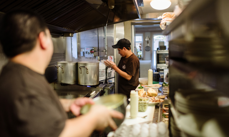 Two cooks preparing meals in the restaurant's kitchen.
