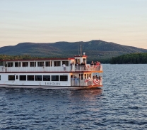 A boat on a lake with mountains in the background.