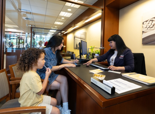 Personal Banker with a customer and her child.