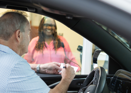 WSB teller helping a customer in their car at the drive-through window.