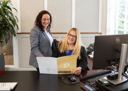 Personal Bankers discussion customer options while looking at bank brochures.