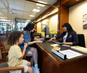 Personal Banker with a customer and her child.