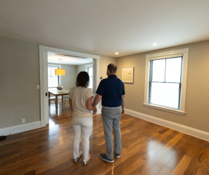 A couple walking through an empty room of their newly built house.