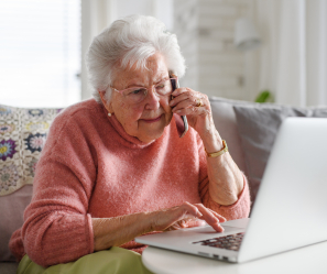 Senior woman on the phone and computer.