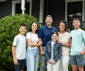 Family standing in front of their house.