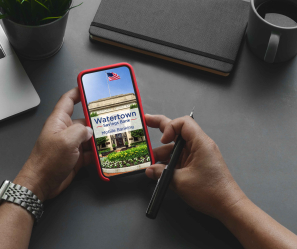 Person checking their WSB Mobile Banking app with a laptop nearby.