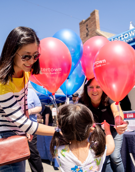 Local residents stopping by a WSB tent at Belmont Town Day and receiving balloons from an employee.