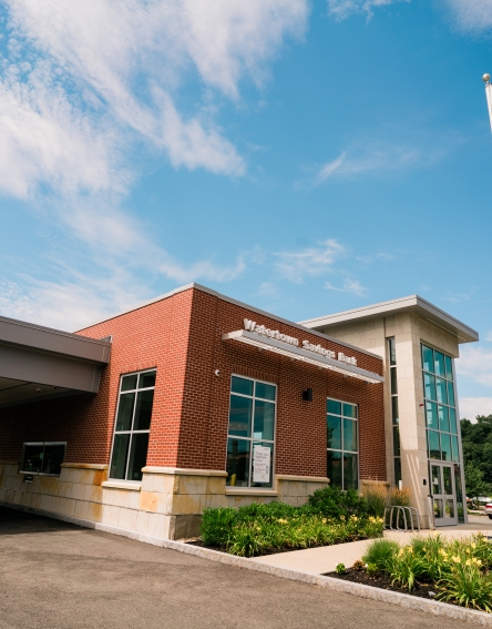 Large building with a drive-thru on the left and a tall flag pole with an American flag.