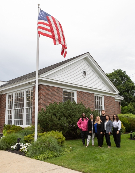 Staff standing on the grass next to the Warrendale Branch and bank name.