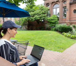 Woman checking her WSB bank account on her computer outside the library.