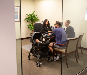 Young parents with a baby in the stroller having a meeting with a Loan Officer at Watertown Savings Bank.