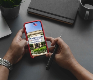 Person checking their WSB Mobile Banking app with a laptop nearby.