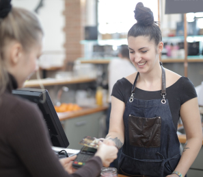Woman paying with a debit card at a cafe.