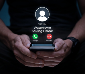 A person holding a phone with an incoming call from Watertown Savings Bank and two buttons 'accept' or 'decline'