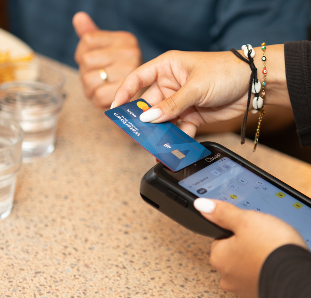 Waitress tapping a WSB debit card to make a contactless payment.