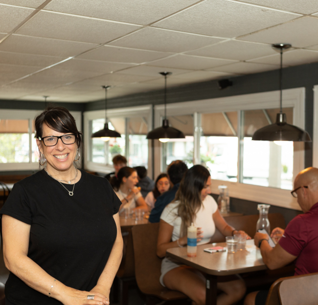 Restaurant owner with customers dining.