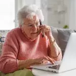 Older woman on the phone and laptop